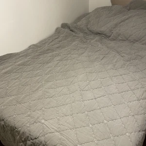Överkast | Grå | Mio - Ett grått överkast i skönt material och fint mönster.  Mått: 180x260 cm