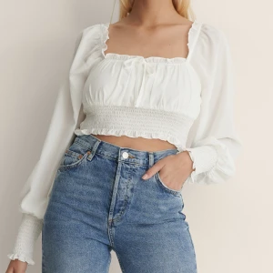 Vit Topp med smock i midjan nakd  - ”Croppad topp med smock i midjan” från Nakd i storlek 34. Endast använd en gång. Köpt för 329, säljs för 70.💕