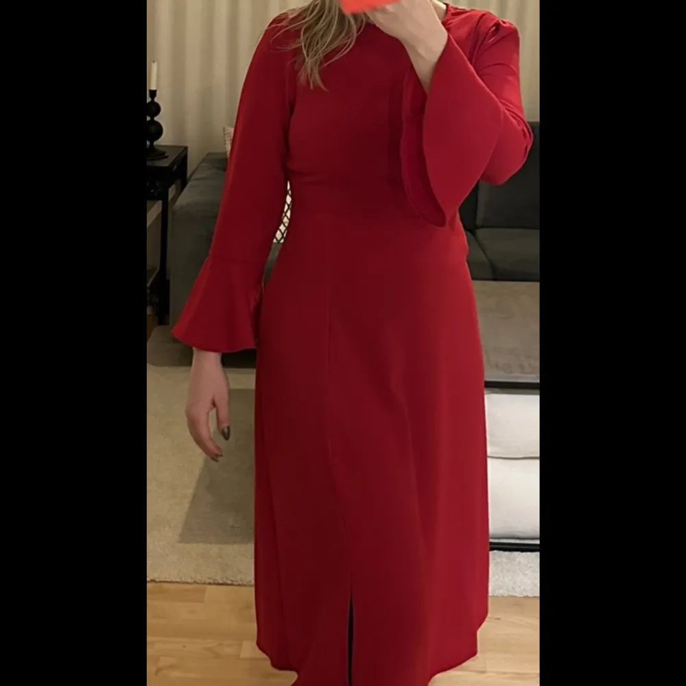 Superfin röd klänning med trumpetärm. Knappt använd. Sytt med symaskin för att stänga en del av slitsen som inte syns på klänningen (se bild 3)❤️  Hör gärna av dig om du har frågor!. Klänningar.