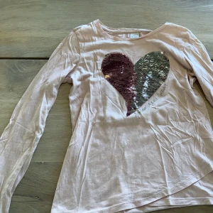 Långärmad tröja  - Det är en super fin tröja från Lindex, paljetterna går att ändra färg på genom att dra dom upp. Med tyvärr lite spild lila målarfärg på armen. Den är i storleken 146/152.