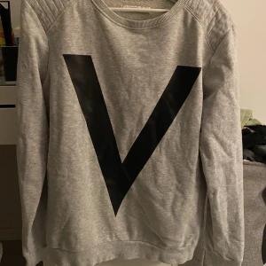 Grå tjocktröja  - En tröja i grått med svart tryck på i strl M från ivyrevel. 45kr+frakt