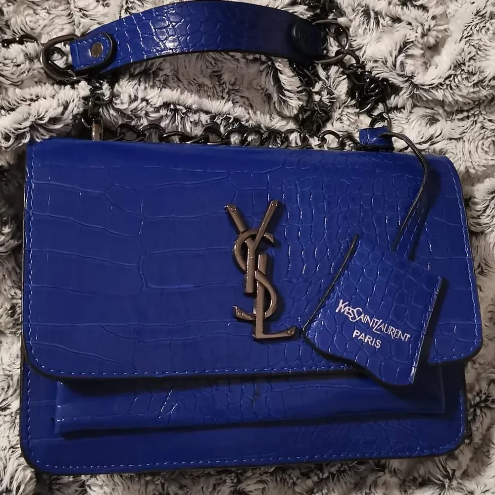 Ny super snygg YSL kopia i blått ormskinsliknande mönster. Är en mindre väska Finns liiiten defekt på kant på insidan som knappt syns . Accessoarer.