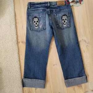 Lågmidjade jeans - Jeans från märket Misso&y som är lågmidjade. Dom är korta i benen för mig som är 160. Dom har dödskallar på bakfickorna och en fram. Köparen står för frakt!