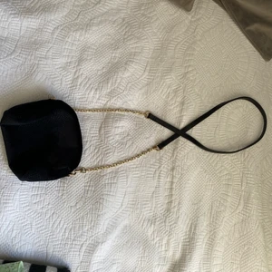 Liten handväska - Denna väska är liten men snygg, den är svart och tyger påminner lite om Manchester (stav) 