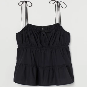 Svart topp med knytband  - Säljer denna jättefina och trendiga topp som är slutsåld på HM:s hemsida!💞 använd ca 2 gånger och är i bra skick. säljer pga att den inte kommer till användning. ❗️ser lite bösig ut på andra bilden men inget som har försämrat toppens skick på nåt sätt❗️ storlek 32 och passar bra på mig som bär XS/S i toppar. kom privat för intresse 🫶 