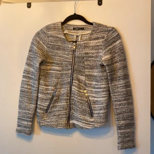 Ginatricot, kofta - Fin melerad kofta grå/vit med silvriga detaljer från ginatricot