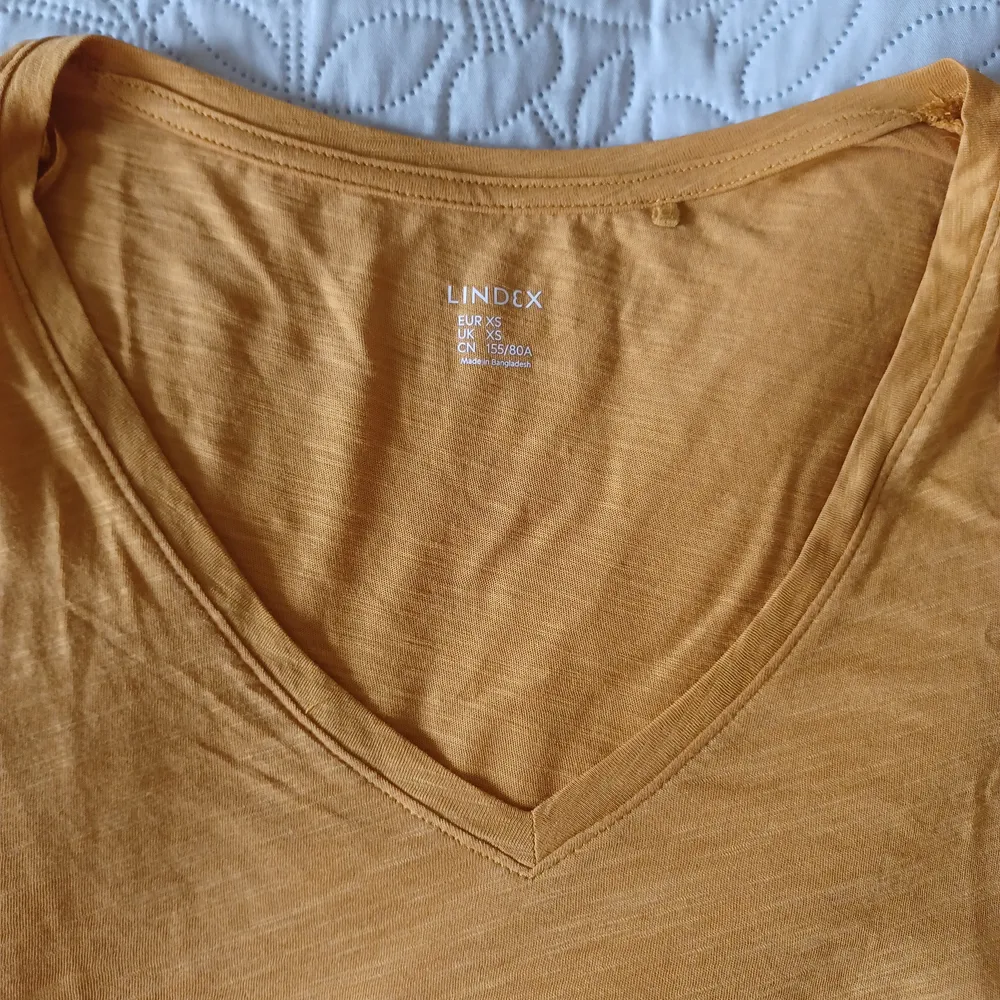 En senapsgul V-ringad t-shirt. ~ Varan kostar 20kr och frakten kostar 29kr.. T-shirts.