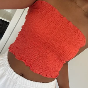 Orange bandeau topp från Gina Tricot - Jättefin topp från Gina Tricot. Har använt den en gång så den är i nyskick! Storlek M men kan även passa mindre/större då det är stretch. 