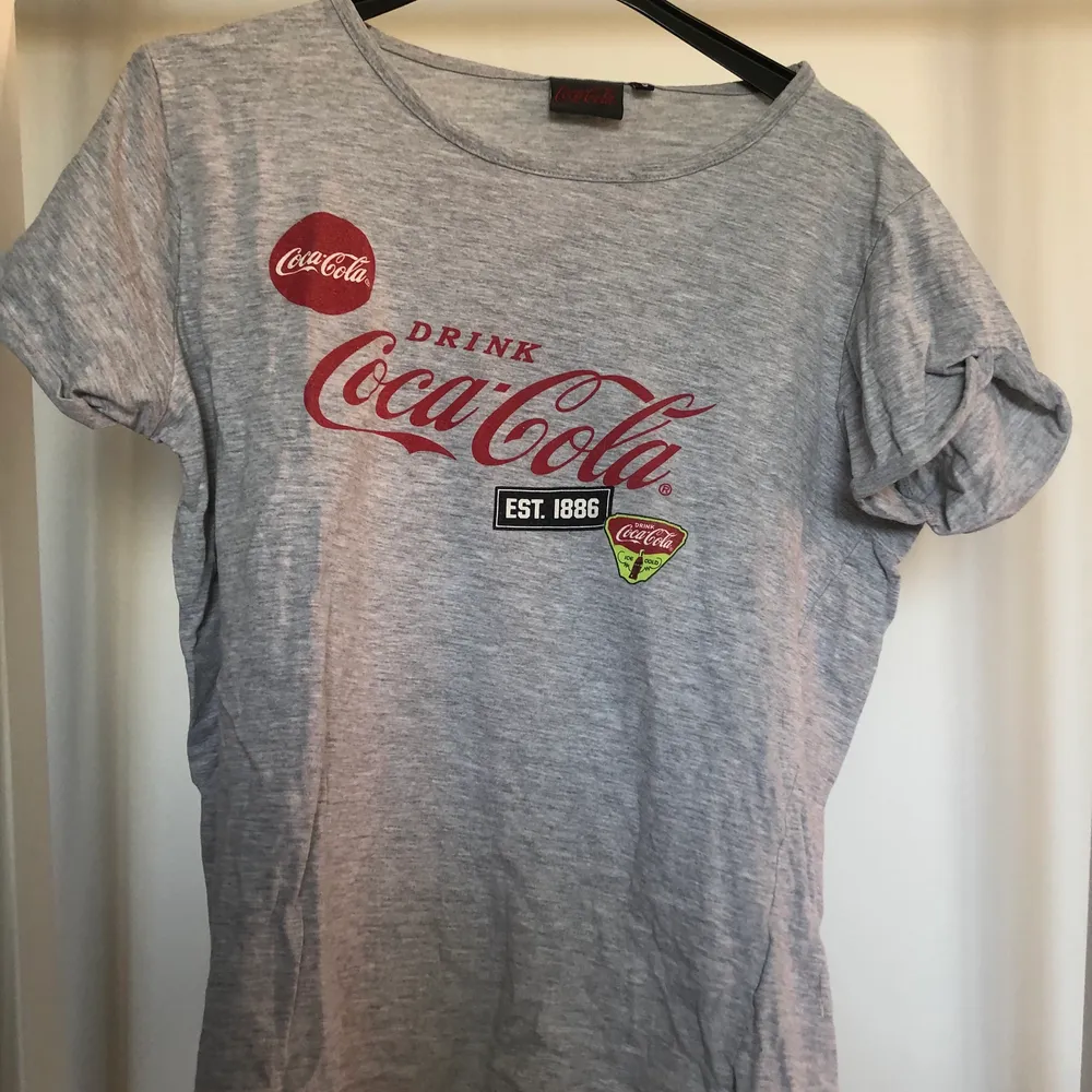 Fin grå t-shirt med coca cola tryck. . T-shirts.