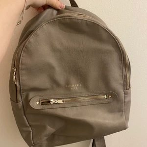 Grå ryggsäck från H&M  - Säljer denhär gråa ryggsäcken från H&M. Väl använd men inga skador! Guldiga detaljer. 