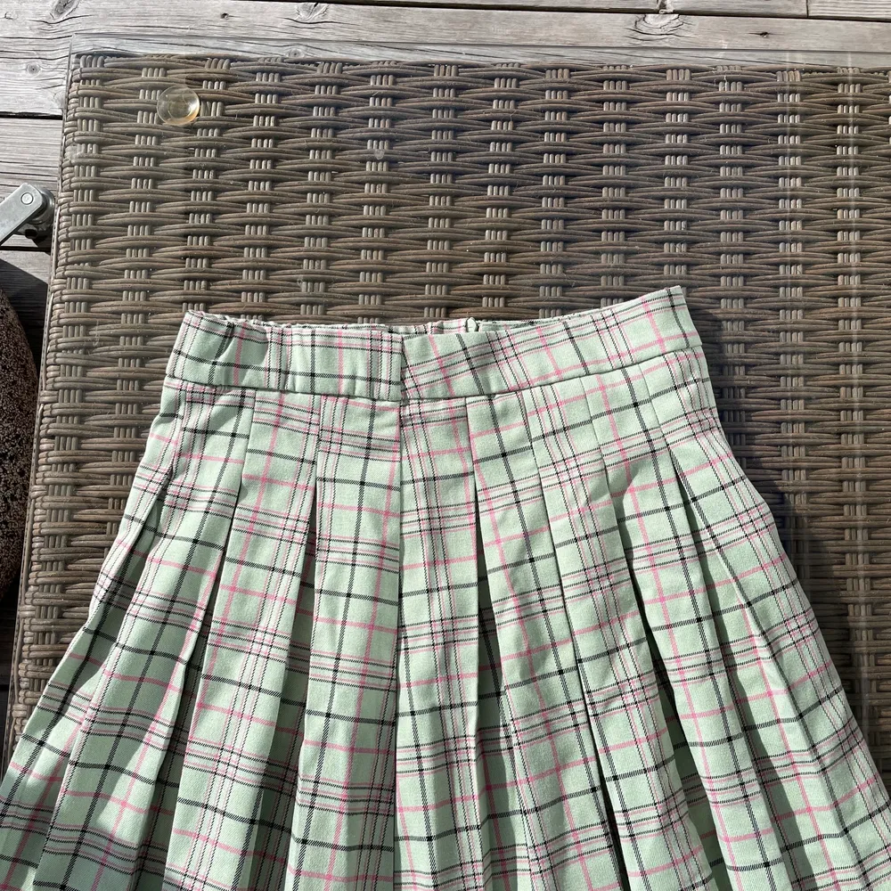 En tennis kjol som e rutig med färgen grön och små detaljer med svart och rosa men det är ett mjukt material  och det är en liten slits med dragkedjor som går ner långt, andvänd 2 gånger och i som nytt skick! Säljer denna för att jag aldrig andvänder denna! Du står för frakt som är 45 k💚🖤💜. Kjolar.