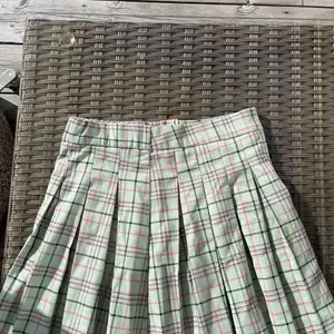 En tennis kjol som e rutig med färgen grön och små detaljer med svart och rosa men det är ett mjukt material  och det är en liten slits med dragkedjor som går ner långt, andvänd 2 gånger och i som nytt skick! Säljer denna för att jag aldrig andvänder denna! Du står för frakt som är 45 k💚🖤💜
