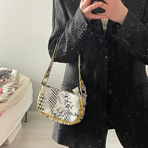 Cool miniväska tidningsmotiv  - Supersnygg miniväska från asos med tidningsmotiv och gula konturer. Använd 1 gång!