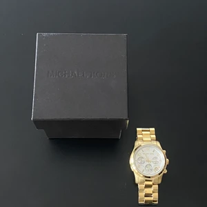Michael Kors klocka  - Michael Kors klocka i guld. Köpt på Stjärnurmakarna för 2700 kr. Extralänkar och orginalbox medföljer.
