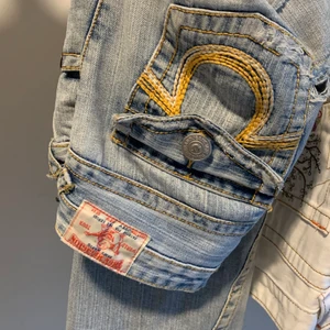 True religion jeans - Ljusa true religion jeans med hål på låren. De är i bootcut modell, jag är ca 163,5cm. Bara höra av sig vid frågor. Använd inte köp nu funktionen :)