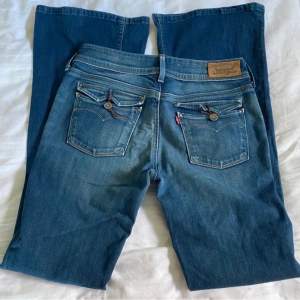 Ett par lågmidjade blå jeans som jag köpte på Plick men som tyvärr inte passade mig. De är ifrån Levis och har skitsnygga detaljer på fickorna. Midjemåttet är 84cm och innerbenslängden är 86. Köp inte direkt. Köparen betalar för frakten