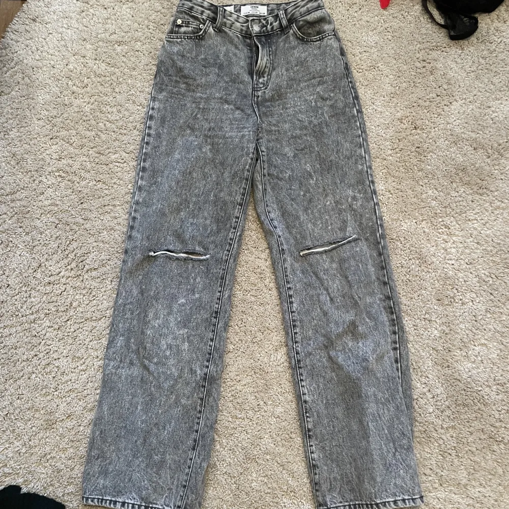 Stengrå jeans med slitningar på knäna, sitter snyggt på, högmidjade. . Jeans & Byxor.