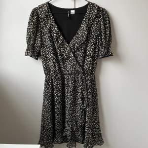 Omlottklänning från H&M med lite volanger på armar och nederdelen. Sista bilden visar mönster och färg. Storlek 36, använd fåtal gånger. Säljes pga för liten.😊