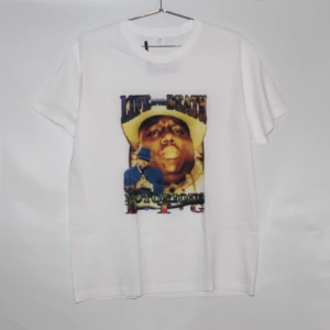 T-Shirt Notorious B.I.G - Gör dig redo för dessa snygga Notorious B.I.G T-shirts. Unisexdesignen gör den lämplig för både tjejer och killar och det mjuka bomullsmaterialet ger en bekväm känsla hela dagen. VIT- St L GRÅ -St M  RÖD - St L  Svart - St L