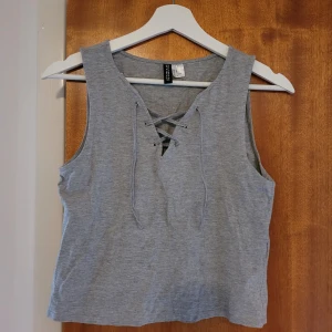 Kortare linne med snöring - Precis som ny.   Kortare i modellen, strlk M, passar även XS och S. Längd från axlarna: 45 cm 