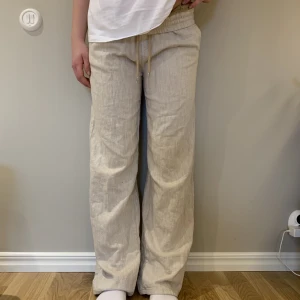 Linnebyxor - Linnebyxor i beige med lite tjockare material perfekt för både vår och sommar!! Använd ca 5 ggr då de är för långa för mig!💗 Min syster är modell för byxorna och är 160cm och de är lite långa fortfarande! Har mer bilder om det behövs!