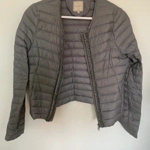 Dunjacka  - Tunn, grå dunjacka från cream med silverbroderi! Stl XS, pris 200