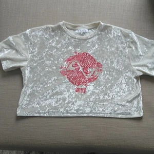 Croptop i sammet och röda karpar  - Topp i croppadmodell. Krossad sammet beige/vit färg. Rött tryck med röda karpar. 