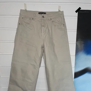 Beiga jeans från Carlings - Vita/beiga jeans från Carlings Stay. Hög midja, vida ben. Slutar en bit över anklarna på mig som är 173 cm. 