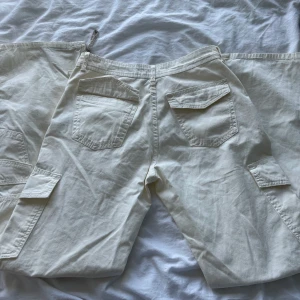 Cargo pants  - As coola lågmidjade vita cargo pants från zara, storlek 36. Dom är för långa på mig som är 167 vilket har lett till defekter längst ner men går bort i tvätten! Köpt för 350kr tror jag, och dom är inte genomskinliga