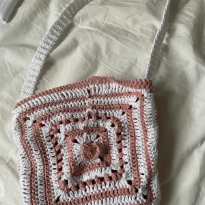 Virkad väska! - Söt virkad väska i rosa och vitt! Handgjord av mig. Finns i flera olika storlekar och färger, väskan på bilden är minsta. Hör av er🌸