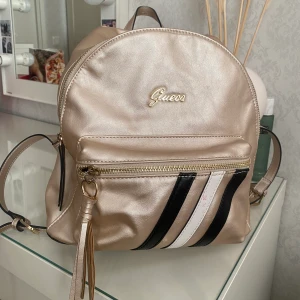 Guess ryggsäck  - Väskan är äkta. Den är använd men är i ganska fint skick fortfarande. 