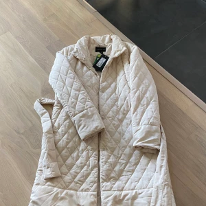 Keyla quilted coat (ljus beige) - Aldrig använd och prislapp sitter kvar.    Köpt för 1 299kr och säljer för 500kr plus frakt. Jättefin höst och vinter jacka 🍂💗