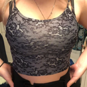 Svart/ grå linne - Grått croppat linne med svarta och vita blommor.XS men stretchig.