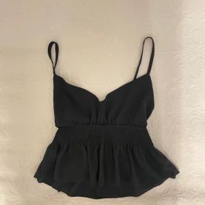 Svart volang linne  - Säljer detta svarta linne med lite volanger! I superbra skick men kommer inte till användning 🖤