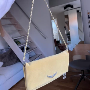 Zadig & Voltaire Rock väska - Säljer min ursnygga Zadig väska i modellen Rock, gul färg! Perfekt till våren & sommaren💛💛Har använts sparsamt. Längre band/kedja till väskan samt dustbag ingår🫶Verkar inte finnas att köpa ny längre men nypriset var 3000kr