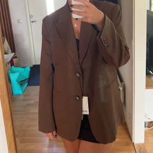 Brun kavaj - Endast använd en gång, ifrån NA-KD och är i storlek 36 men sitter mer som 38. 