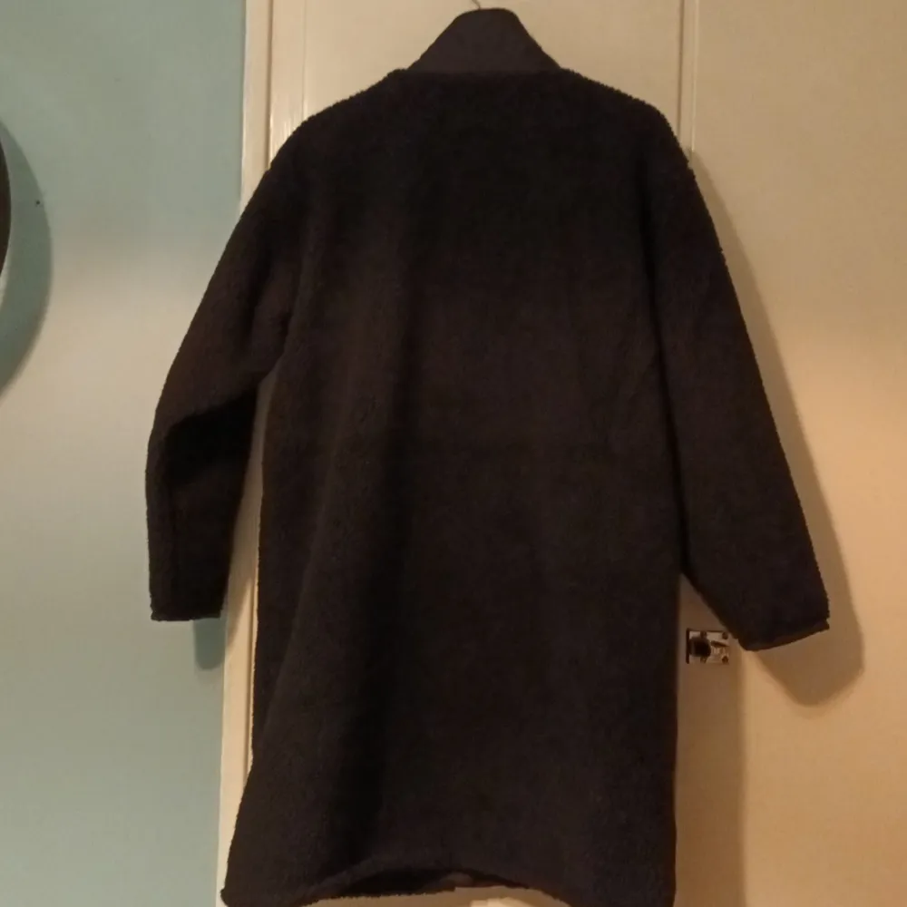 Knälång jacka i pile. Ståkrage. Rak rymlig modell.stl S. Har en vit lina dan i stl M. Nypris 1299:-. Takit.
