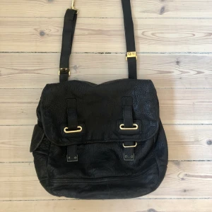 Väska Yves Saint Laurent YSL  - Säljer min väska från Yves Saint Laurent. Den är använd men i fint skick. Den är den perfekta rymliga vardagsväskan som rymmer mycket. En axelväska från YSL är alltid trendigt. Svart skinn och spännen i mässing. Äkta med märke inuti och broderat i botten.