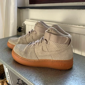 Nike air force beige suede storlek 37,5 - Höga Nike air force i beige mocka. De är använda men omhändertagna, mockat är impregnerat. De står bara hemma hos mig så behöver ny ägare. Storlek 37,5. Nypris 1100kr på Nikes hemsida.