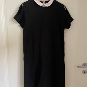 Svart klänning med Peter Pan-krage - Svart klänning från Mango med Peter Pan-krage. Öppningar vid axlarna. Obs hund finns i hemmet.