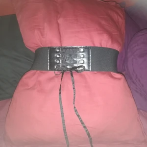 Mdjebelte med snörnig - Ett stretskift midje belte med dekorativt korset snörning fram till och trycker knappar bak till 