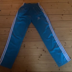 Addids byxor loose fit - Jag säljer dessa blåa Adidasbyxor som är jätte fina🫶🏻 Säljer pga att de har blivit för små🫶🏻 Skulle säga att det är storlek xs men det står att det är storlek m🫶🏻🫶🏻