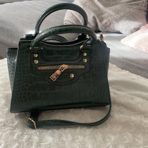 Grön väska med fina gulddetaljer!  - Säljer denna fina väska i ny skick (aldrig använt)  80kr+ frakten (budgivning om fler är intresserade) högsta bud nu är 100+frakt 