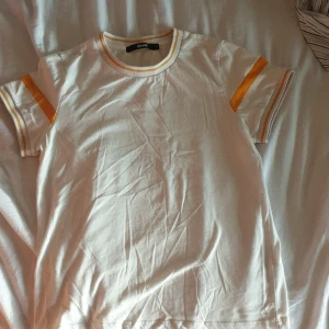 Vit och gul t-shirt storlek S - Fin o mjuk vit t-shirt med gula detaljer. Knappt andvänd och har en retro kännsla ☆ (fraktpriset kan skilja sig lite då jag postar med frimärken!) 