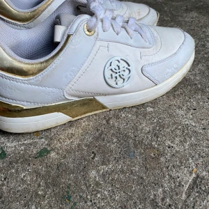 Guess skor - Vita Guess skor med guld detaljer, användna men kommer att tvättas innan de skickas, kommer bli mycket renare. 💵-200kr storlek 37