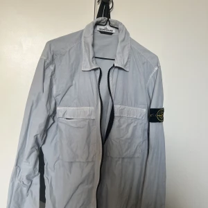 Stone island overshirt - Fin ljusblå stone island overshirt jacka, perfekt nu till våren i storlek M. Äkta QR kod finns