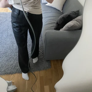 Svarta skinnbyxor - Säljer mina vida svarta byxor i PU läder från NA-KD. Sällan använda och i bra skick. Säljer då de inte kommer  till användning för mig. Storlek 36. 