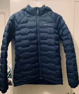 Peak dunjacka - Lättviktsdunjacka från Peak Performance. Material: 100% polyester  Färg: Mörkblå Storlek: 160 (funkar även för XS) Skick: Mycket fint, sparsamt använd Nypris: Ca 1500  Finns i Solna men kan också skickas eller mötas upp i innerstaden Stockholm