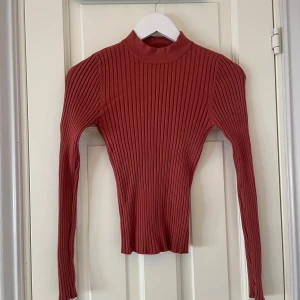 Röd ribbad polotröja  - Snygg röd/typ orange ribbad polotröja från Gina Tricot. Tröjan har en tight passform och långa ärmar. Väldigt fin på men inte min färg längre. Väldigt fin till hösten😊väl använd men syns inte så mycket.