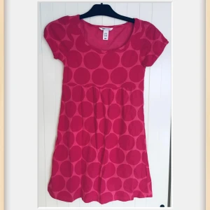 Rosa klänning med prickigt mönster från H&M Young - Säljer en söt rosa klänning från H&M Young med stora prickar. Klänningen har korta ärmar och är tillverkad i 100% bomull, vilket gör den bekväm och lätt att bära. Perfekt för en färgglad look! 🌸